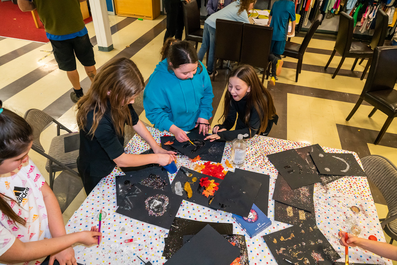 Photo of young people create art around a table