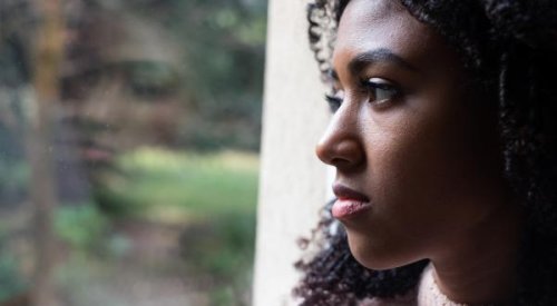 A bereaved woman looking out of a window