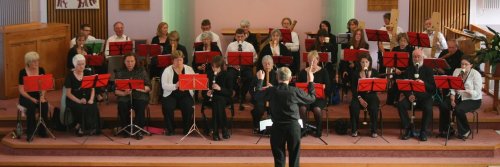 Picture of the orchestra being led by a conductor.