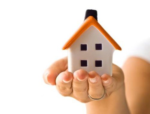 an image of a house being held gentle in a hand 