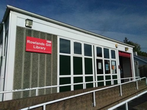 a photo of the outside of the library - a single storey glass fronted building 