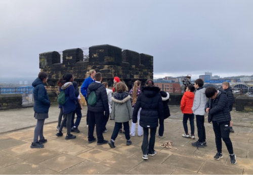 A visitor experience volunteer giving visitors a tour of the castle Keep roof