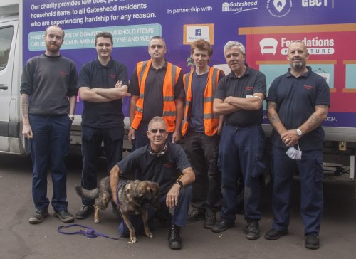 group of volunteers posing for camera in front of a van