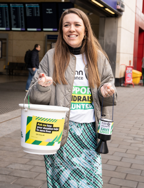 St John volunteer carrying a collection bucket and a tin