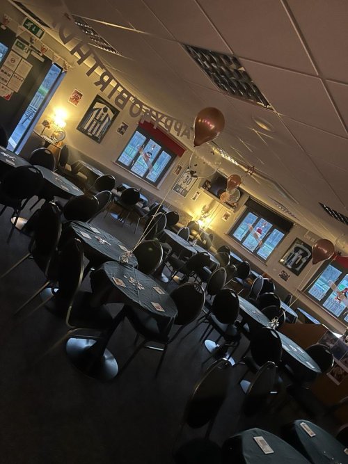 The main room with tables set up for an event with balloons 