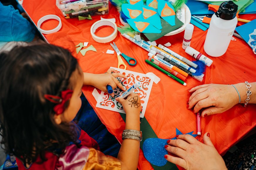 A child drawing on a patterned stencil.