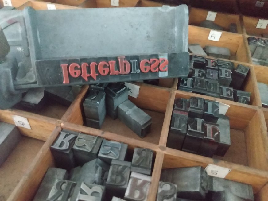 A box filled with an assortment of letter pressed metal stamps.