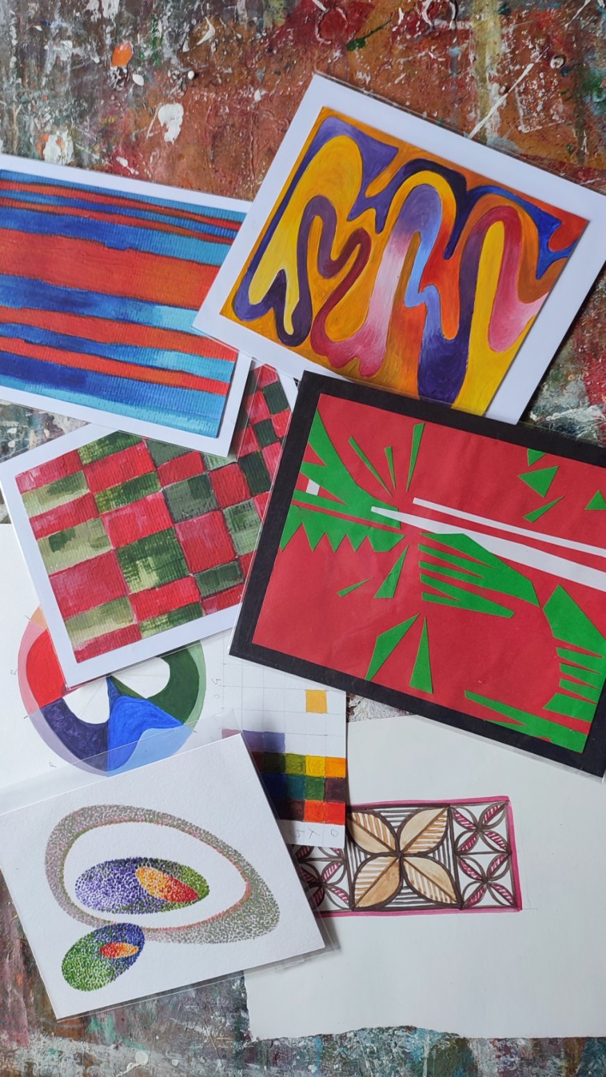 A photo of multiple pieces of art work that vary in colour, pattern, and designs.