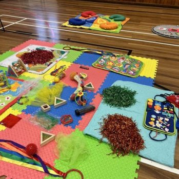 Brightly coloured image showing various toys on a playmat