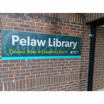Exterior of Pelaw Library building and signage - sign says Pelaw Library discover more at Gateshead Libraries and has Gateshead Council logo.