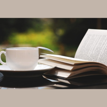 cup with open book beside it