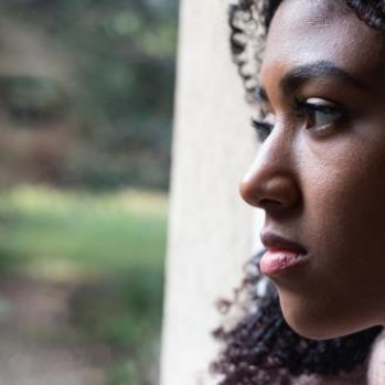 A bereaved woman looking out of a window