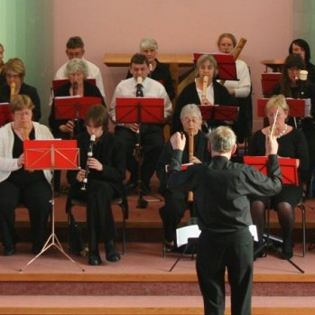 Picture of the orchestra being led by a conductor.