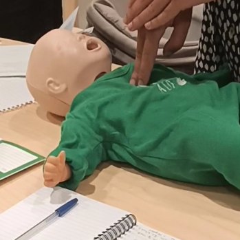 Image shows first aid being demonstrated on a dummy