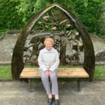a photo of a women seating on the friendship bench