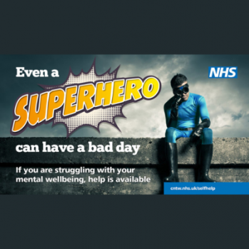 a man dress as a super hero sitting on a wall, with his chin resting on his first looking a bit glum